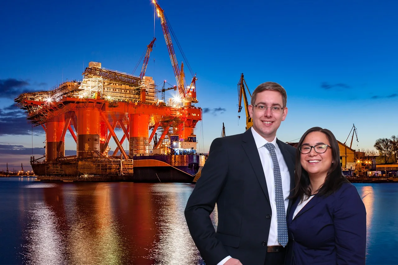 Dieselben zwei Personen vor einer Bohrinsel im Hafen